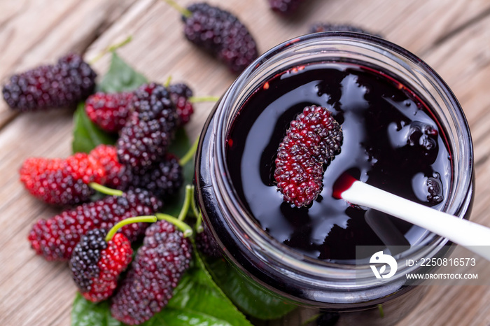 Domestic fresh mulberry jam on a rustic wooden board