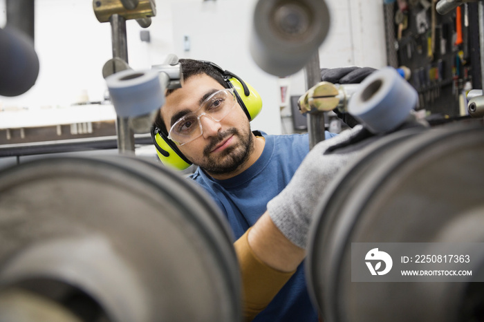 Worker adjusting machine in factory