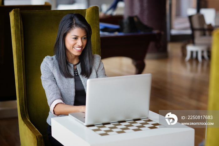 Woman working at laptop in stylish lounge