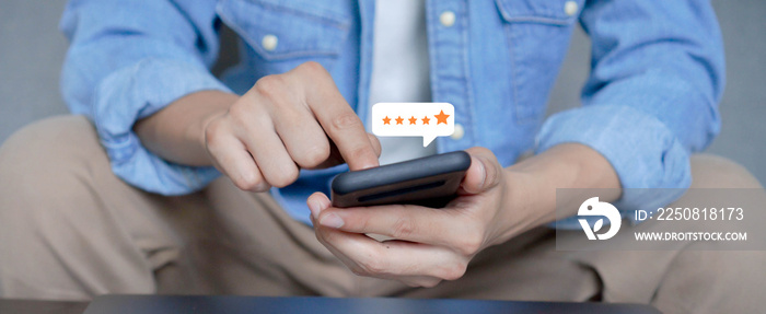 close up on customer man hand pressing on smartphone screen with gold five star rating feedback icon