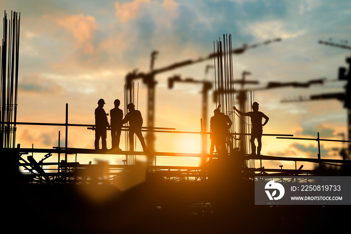 Silhouette of engineer and construction team working at site over blurred background for industry ba