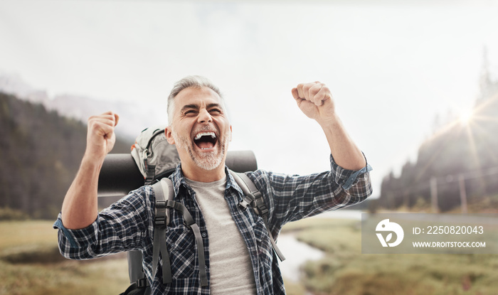 Cheerful hiker celebrating with raised fists