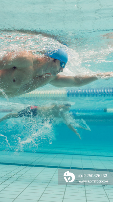 Underwater view male swimmers competing in swimming pool