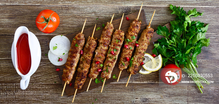 Delicious lula kebab on a wooden table. Chopped meat on wooden skewers, grilled. Eastern cuisine. To