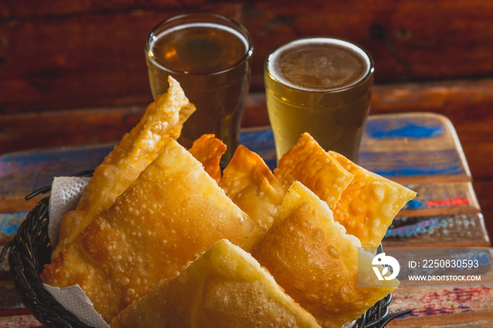 Comida de boteco brasileira salgados diversos servidos em tigelas em balcão de boteco: pastel, bolin