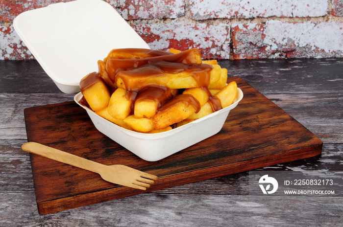 Chips and gravy meal in a take away box with lid