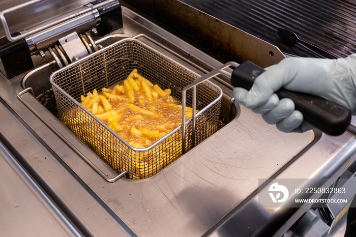 French fries prepared in hot oil in special metal grill