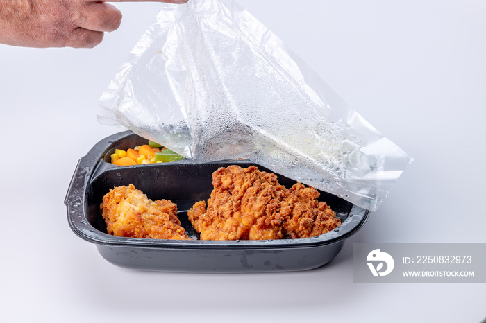 Cellophane cover is removed from a fried chicken TV dinner