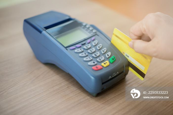 员工正在从信用卡刷卡机上按付款金额。请持有信用卡