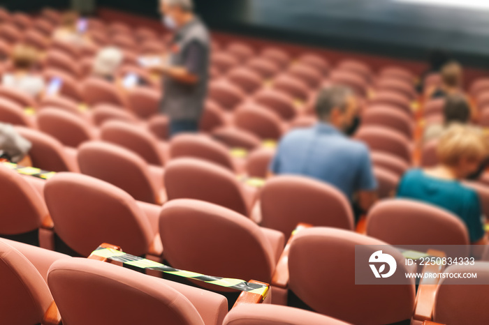 people taking seats while observing social distancing in theater