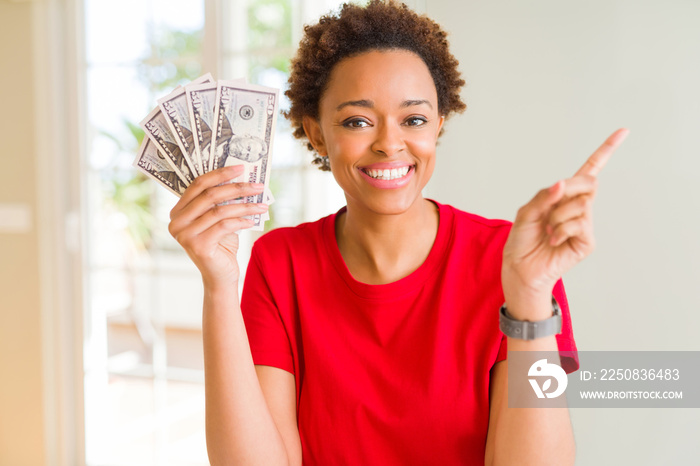 年轻的非裔美国妇女拿着50美元的钞票，非常高兴地用手和手指指着