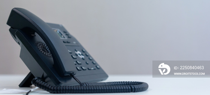站在办公室办公桌上与同事联系的近距离电话VOIP技术