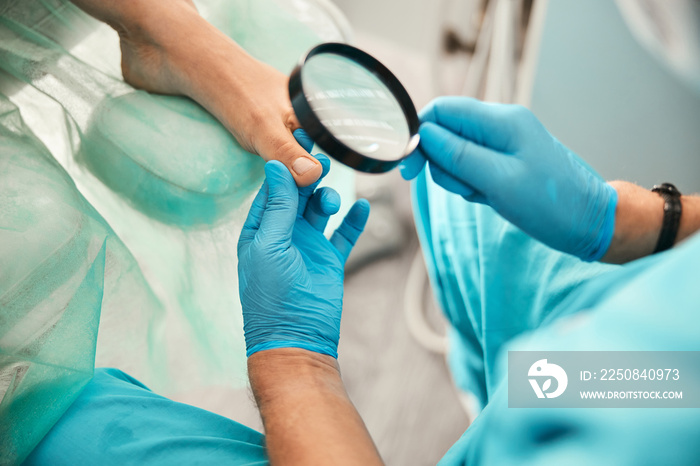 Focused photo on male hand holding magnifying glass