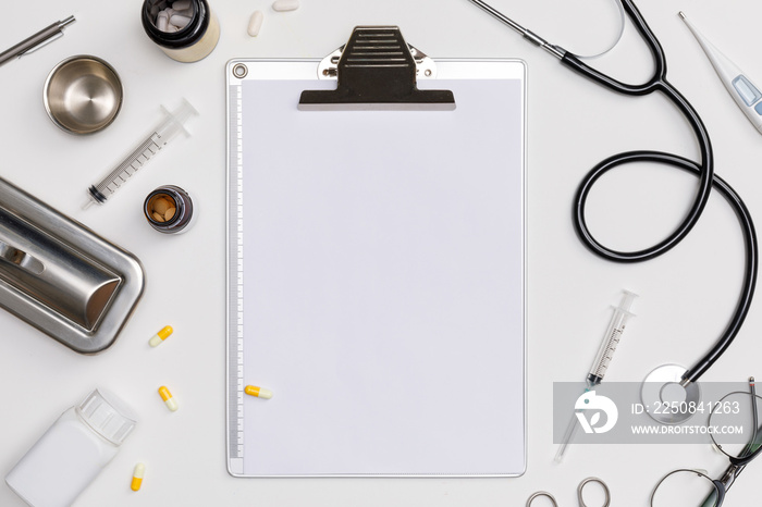 Creative flatlay of doctor medical equipment white table with stethoscope, medical documents, thermo