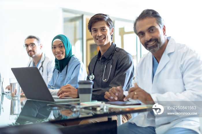 Medical team looking at camera while working together at desk