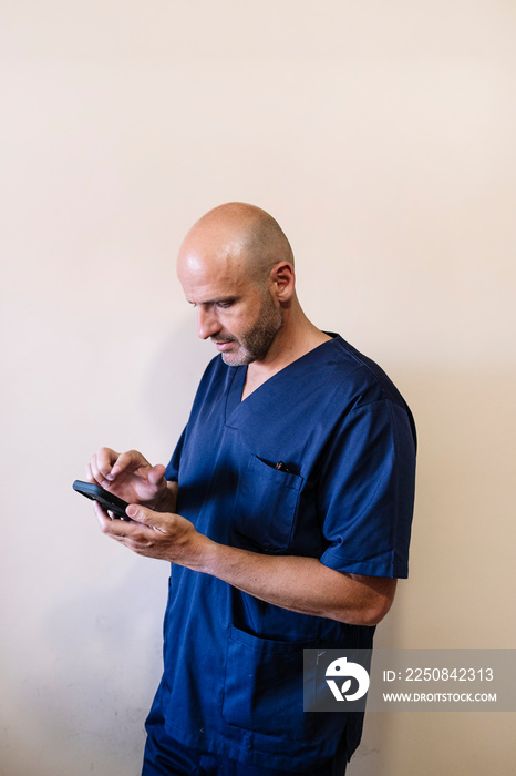 Studio portrait of smiling doctor with smartphone healthcare worker
