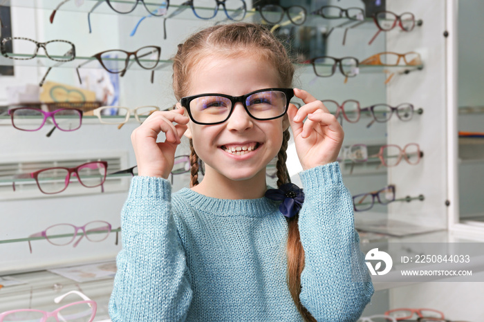 Cute little girl with new glasses in shop