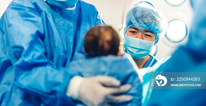Professional anesthesiologist doctor medical team and assistant is performing baby cesarean section 