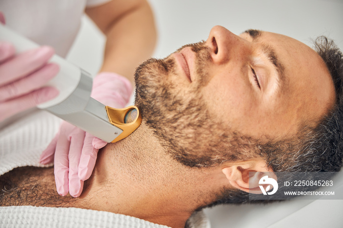 Handsome bearded man having laser hair removal procedure