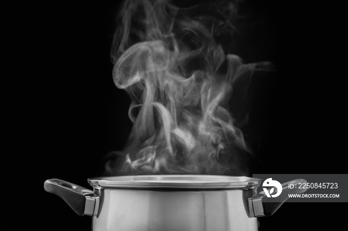 steam over cooking pot in kitchen on dark background