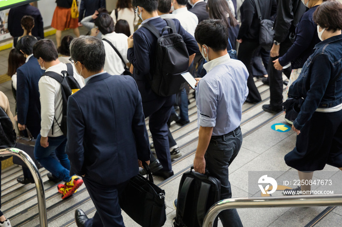 スマホを見ながら出社するビジネスマン