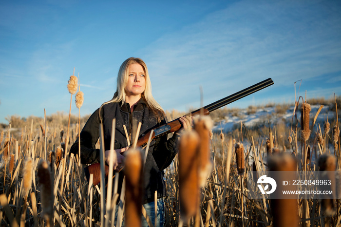 Woman holding rifle in field