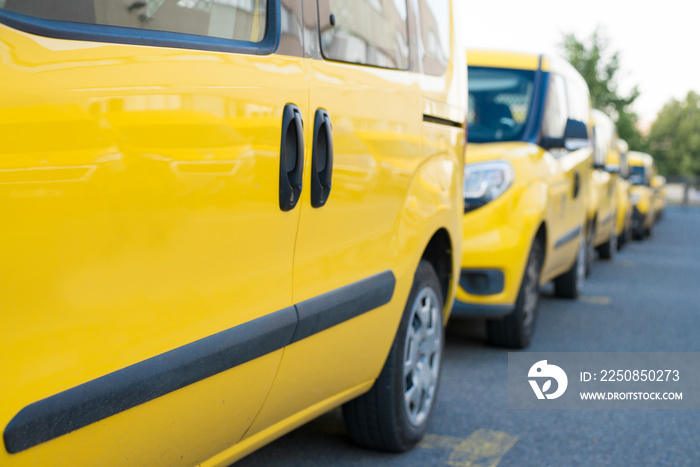 Yellow fleet cars parked in a line. Lined up pick-ups cars.