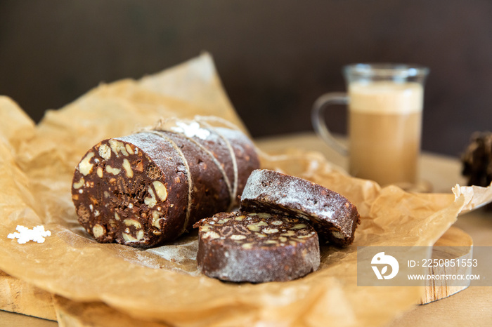 木制背景的自制巧克力香肠。由饼干、巧克力和坚果制成的甜点是s