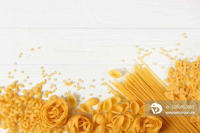 A set of different types of Italian pasta on a colored background top view, place for text.