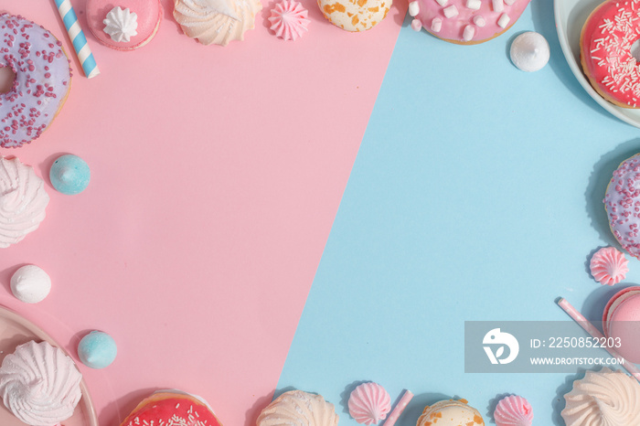 Kitchen utensils and tools, pastries and sweets on a pink and blue background. Top view. Copy space.