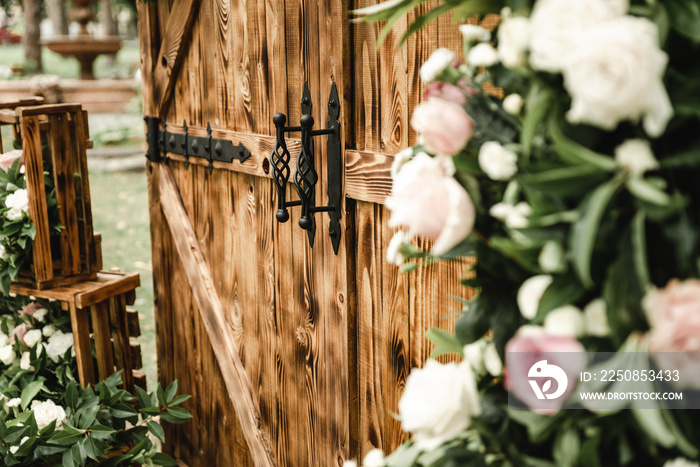 brown wooden decorative doors in loft style are decorated with beautiful fresh flowers, wedding deco