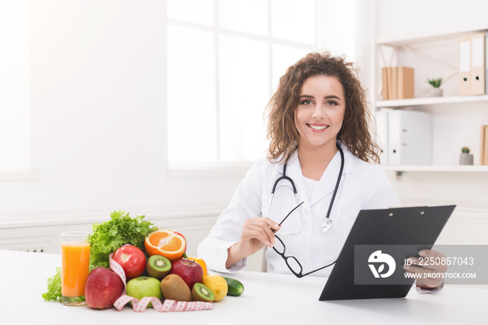 Woman nutritionist showing blank clipboard at office