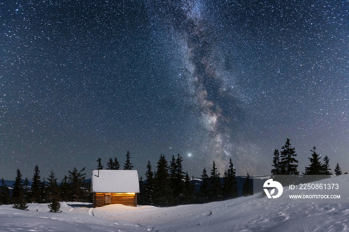 雪山木屋的奇妙冬季景观。银河和雪的星空