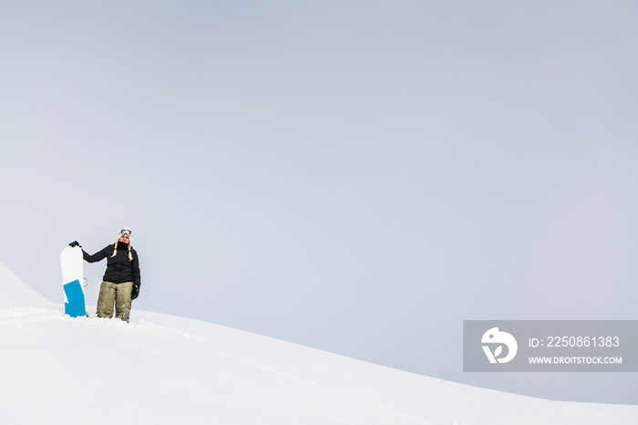 Young female with snowboard, Reutte, Tyrol, Austria