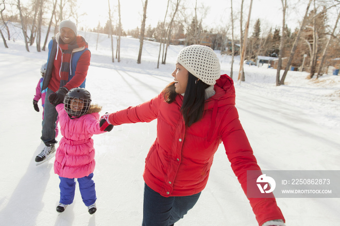 Parents teaching girls how to ice skate