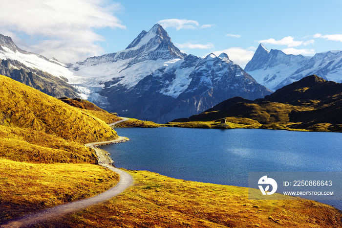 Picturesque view on Bachalpsee lake in Swiss Alps mountains. Snowy peaks of Wetterhorn, Mittelhorn a