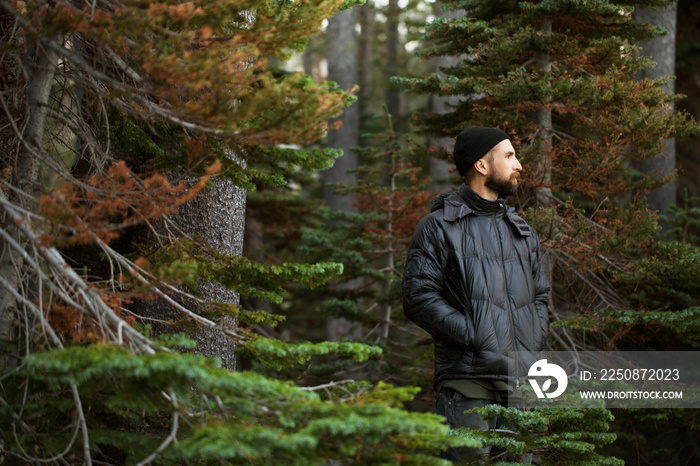 Man in winter coat standing in forest