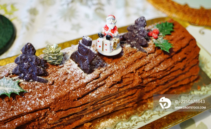 French chocolate yule log cake (buche de Noel) with Christmas decorations