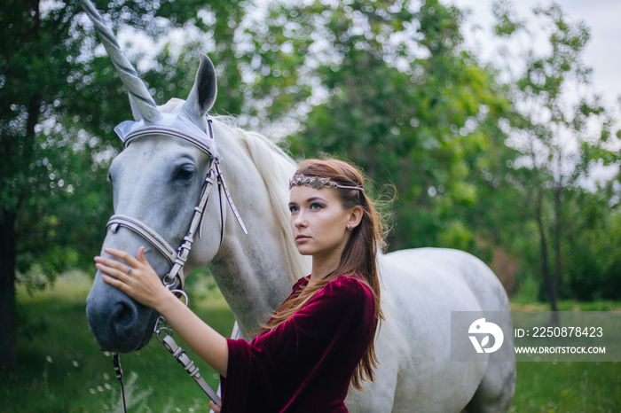 Beautiful girl in red medieval dress with unicorn. Fantasy. Woman Elf