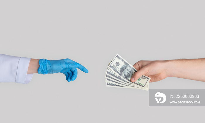 Unrecognizable patient giving money to doctor in rubber glove, closeup of hands