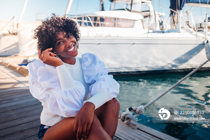 Cheerful happy black african young woman sit down outdor smiling - concept of tourist and summer hol