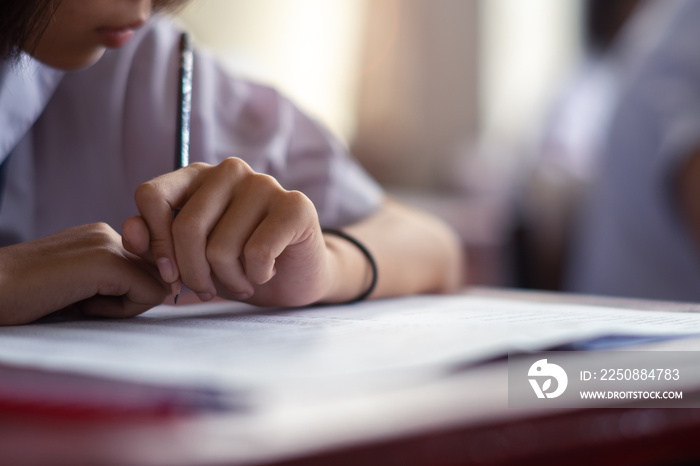 Students taking exam with stress in school classroom.