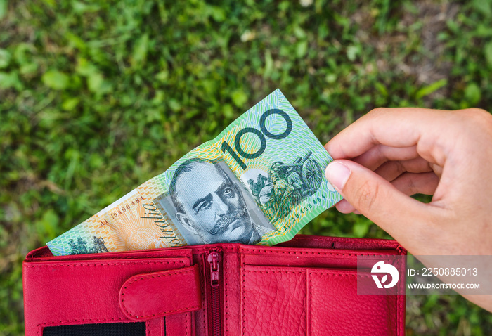 woman hand holds wallet with Australian dollar paper money