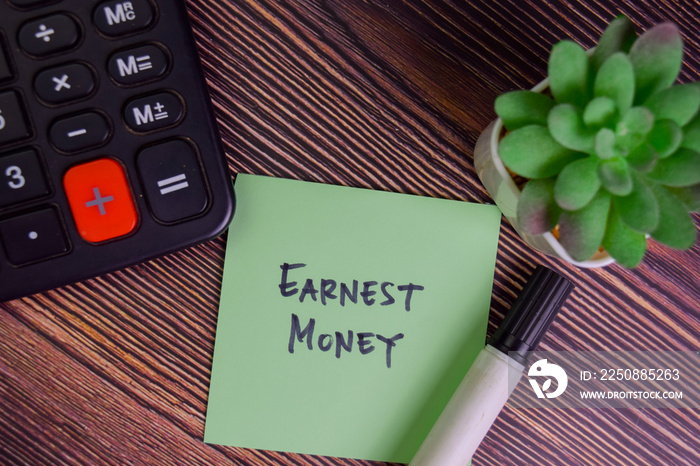 Earnest Money write on sticky notes isolated on Wooden Table.