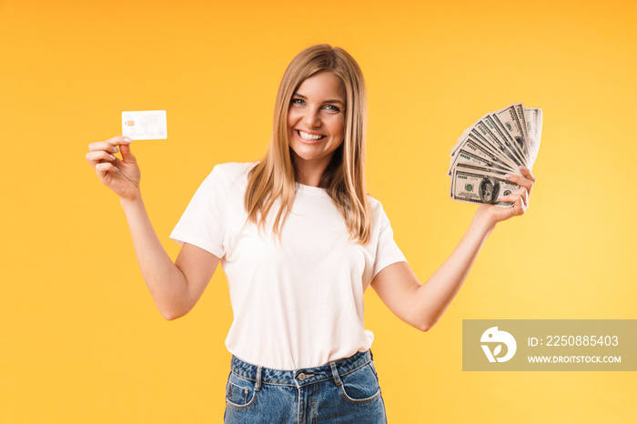 Image closeup of positive blond woman wearing casual t-shirt rejoicing while holding credit card and