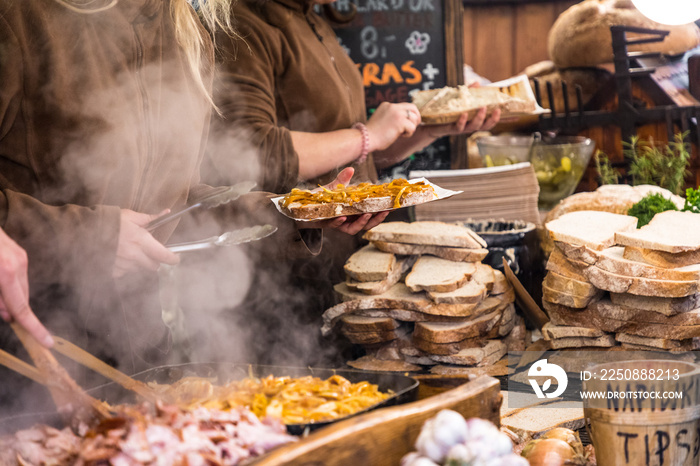 Food booth selling traditional Polish street food in Main Square, Kraków at Christmas market.