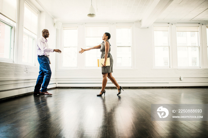 Female real estate agent extending hand in greeting to man