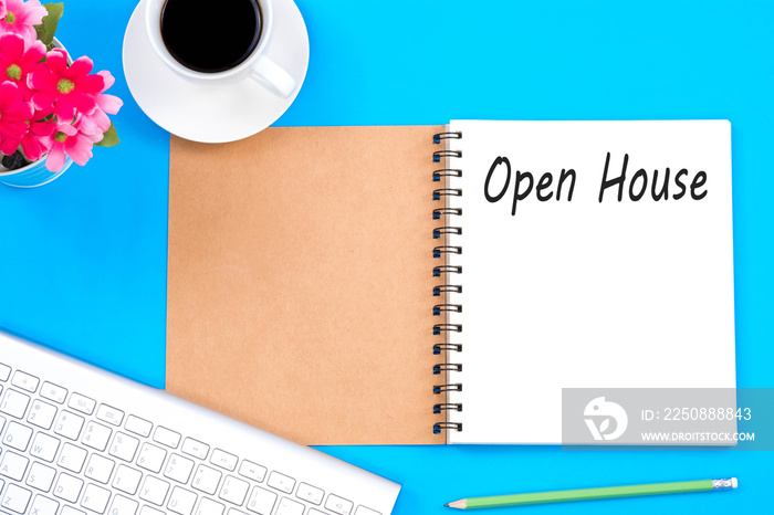 Open house word on notebook, Top viwe of modern workplace with office supplies on blue background.