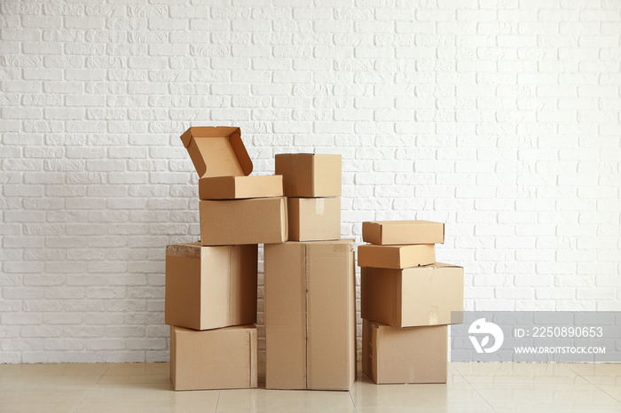 Cardboard boxes near white brick wall