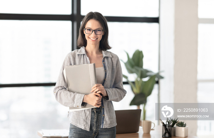 Happy manager smiling at camera in contemporary office